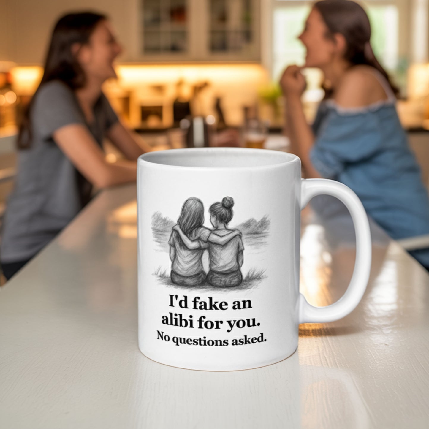 White ceramic mug featuring a pencil-style illustration of two girls sitting side by side with arms around each other, and the text "I'd fake an alibi for you. No questions asked." In the background, two women laugh together at a kitchen island, suggesting a close and playful bond.