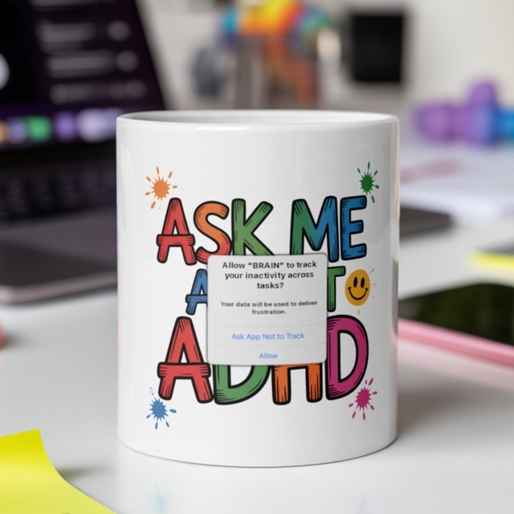 White ceramic mug with colorful text that reads “Ask Me About ADHD,” featuring paint splatters and a humorous fake pop-up message that says: “Allow ‘BRAIN’ to track your inactivity across tasks? Your data will be used to deliver frustration.” Perfect ADHD self gift for adults, neurodivergent workers, or students who navigate executive dysfunction with humor. Ideal for therapists, educators, or anyone who wants to spark conversations about neurodiversity with a funny and relatable touch.