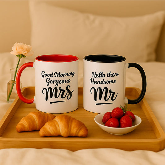 Set of matching Mr and Mrs mugs for couples, featuring black and red interiors and romantic text — “Hello there Handsome Mr” and “Good Morning Gorgeous Mrs” — styled on a cozy wooden breakfast tray with croissants, strawberries, and a flower vase; perfect couple mugs gift for weddings, anniversaries, or morning coffee together.