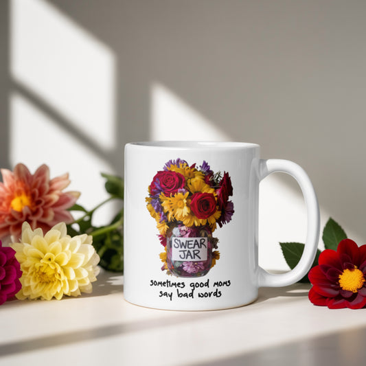 Funny mom mug with swear jar flower design. White ceramic coffee mug features colorful bouquet in a jar labeled 'Swear Jar' and the phrase 'sometimes good moms say bad words' in playful handwritten font. Perfect gift for mom from daughter or son — ideal for Mother’s Day, birthdays, or just because. Styled on a sunny windowsill with fresh flowers and soft natural shadows.
