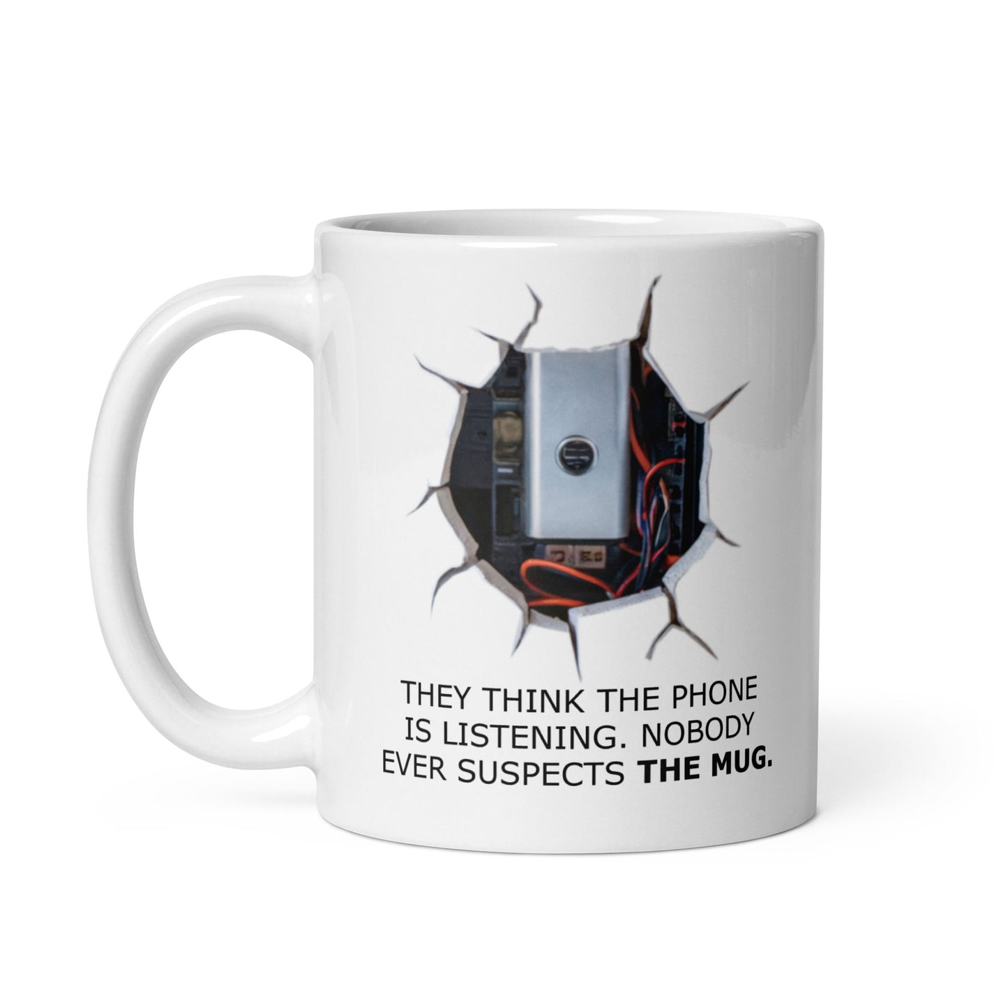 A geek mug gift with a playful printed design depicting a surveillance device and the text 'THEY THINK THE PHONE IS LISTENING. NOBODY EVER SUSPECTS THE MUG.